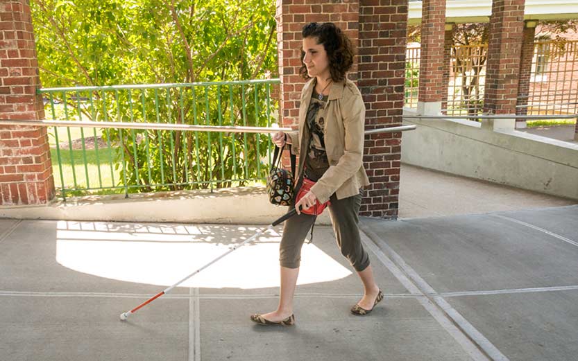 Woman walking while using a long cane