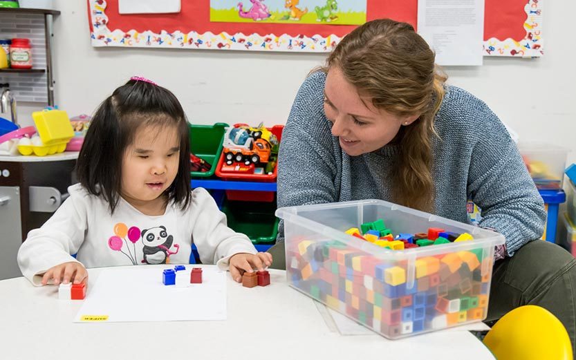 Teacher and student sitting at desk together