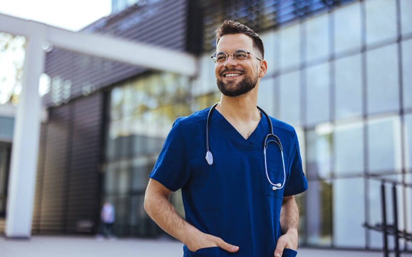 a male nurse outside a hospital smiling