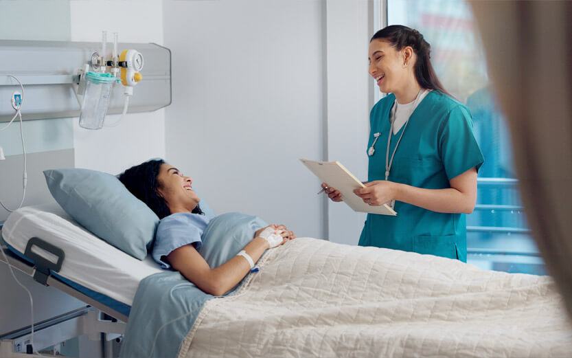 a nurse talking with a patient in a hospital bed before surgery