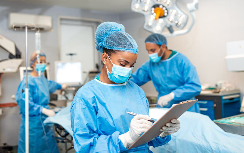 a nurse taking notes on the medical chart of a surgery patient