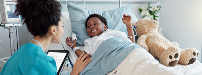 a nurse attending to a young boy in a hospital bed