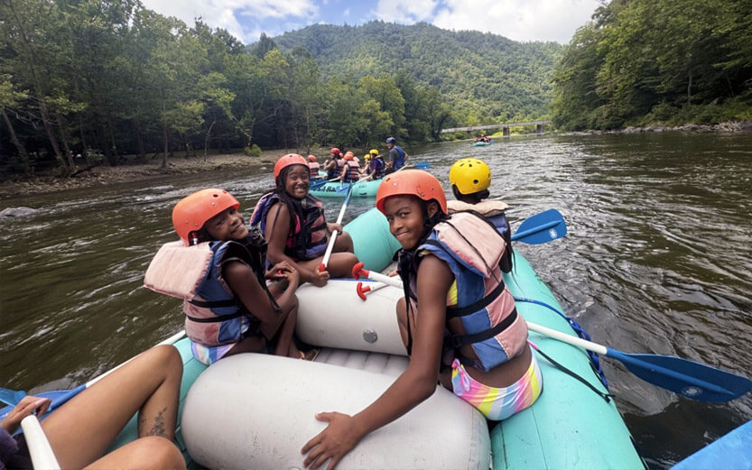 a group of kids rafting in a river