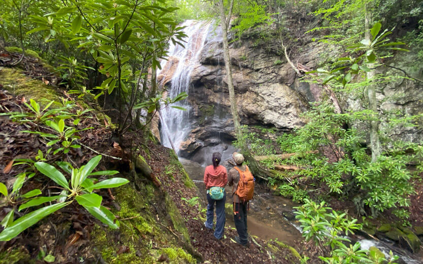two hikers stop to admire a waterfall
