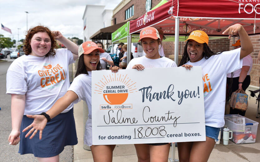 four young women volunteering at a summer cereal drive