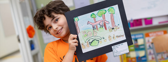 young ASD student holding up drawing