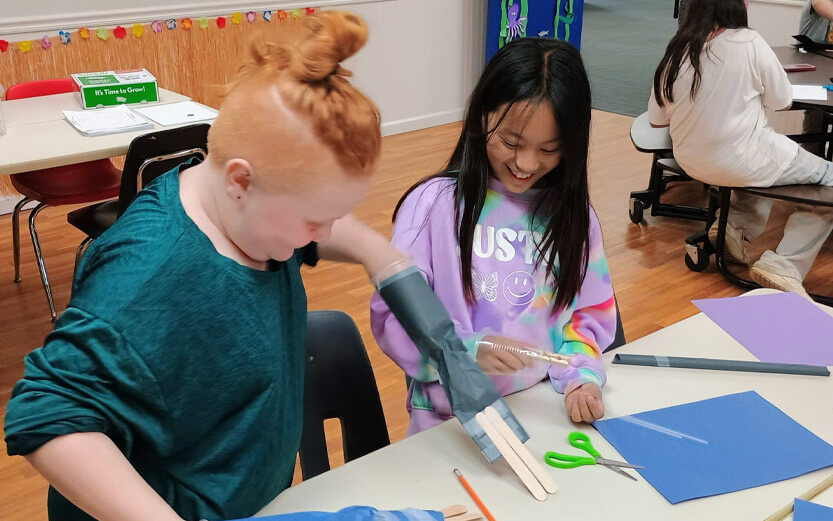 two kids laughing while making crafts