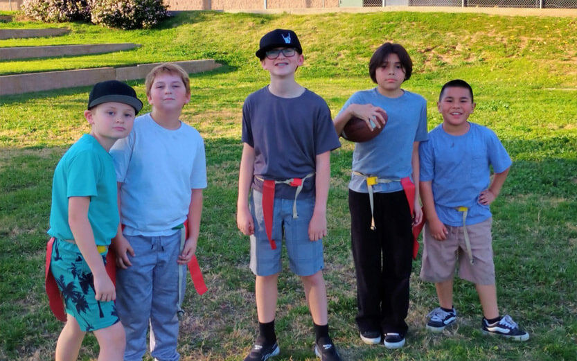 five boys playing flag football