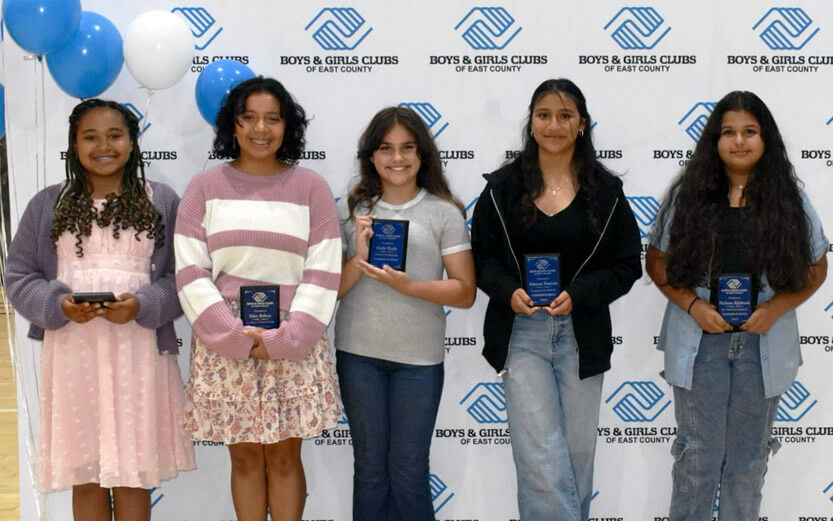five teen girls posing with their award plaques