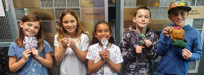 five kids showing off their craft projects