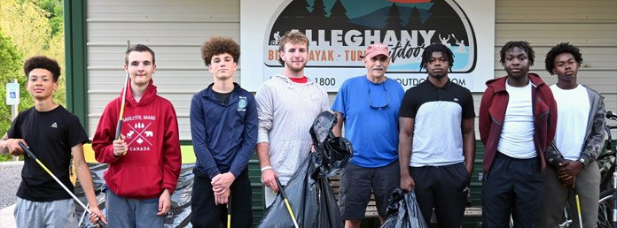 a group of teen boys pose for a photo after picking up litter