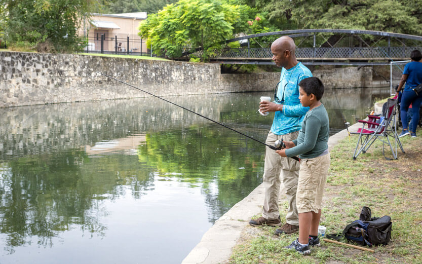 man and boy fishing in the river