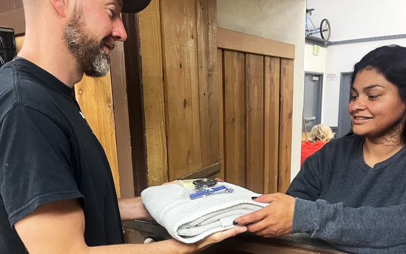a volunteer hands shower supplies to a man