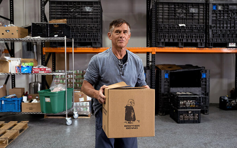 a man holding a box of supplies to be distributed