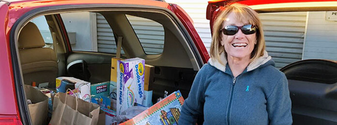 a woman with her car full of donated items