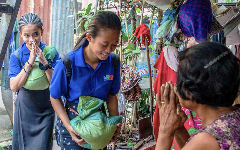 teen girls receiving sacks of rice