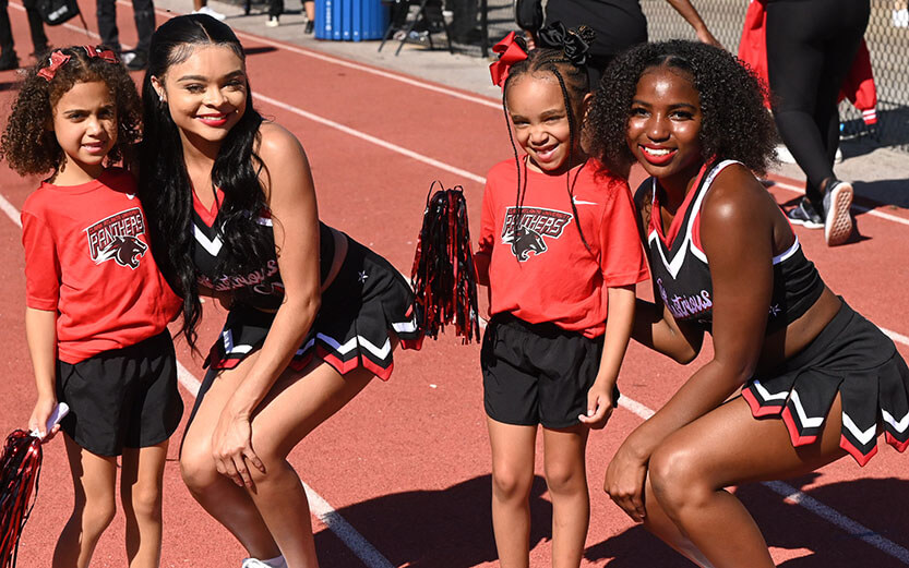 two college-aged cheerleaders with two tween girls