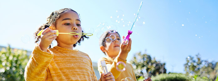 two young children blowing bubbles