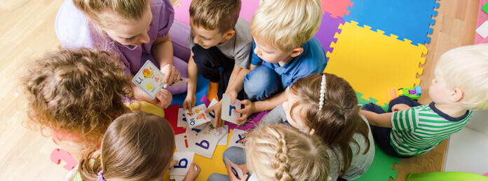 overhead view of a preschool teacher teaching a group of children their ABCs