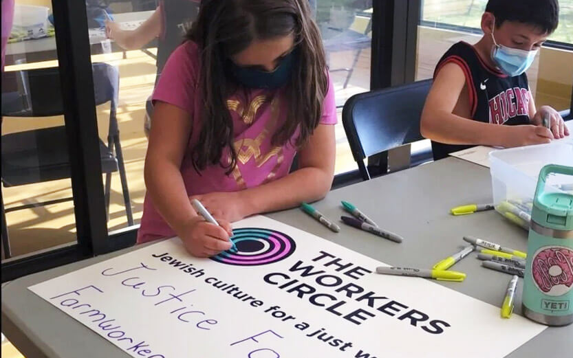 a young girl coloring a sign
