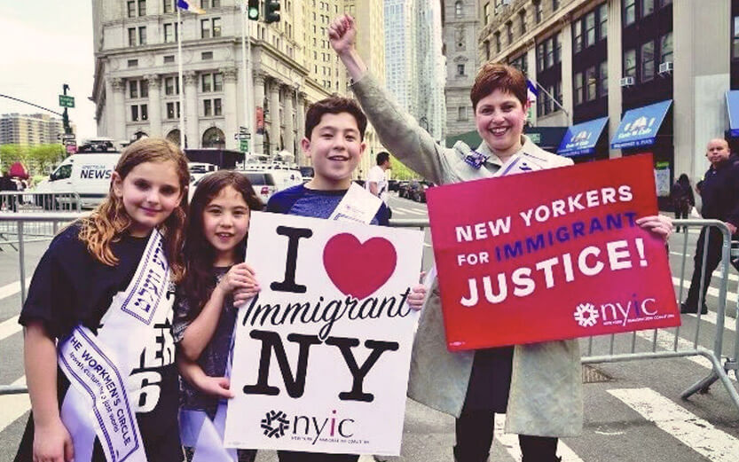 a family holding signs for immigrant justice
