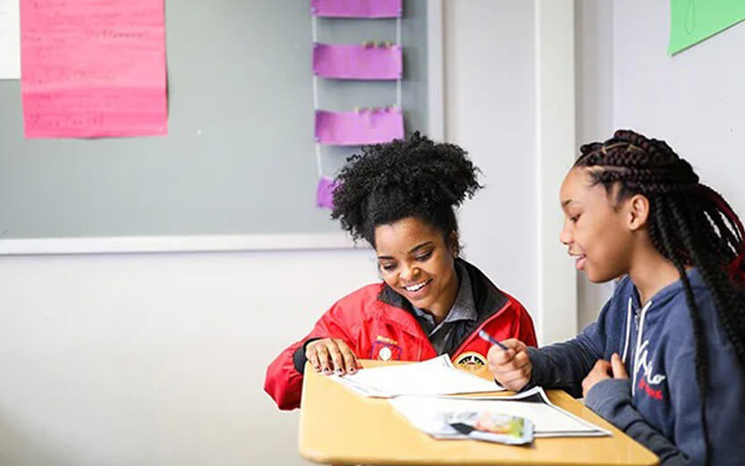 City Year volunteer helping a student with their homework