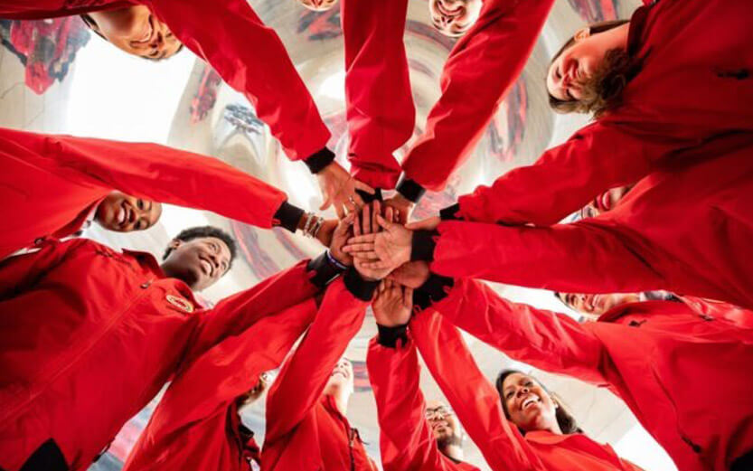 City Year volunteers in a circle with hands in the center
