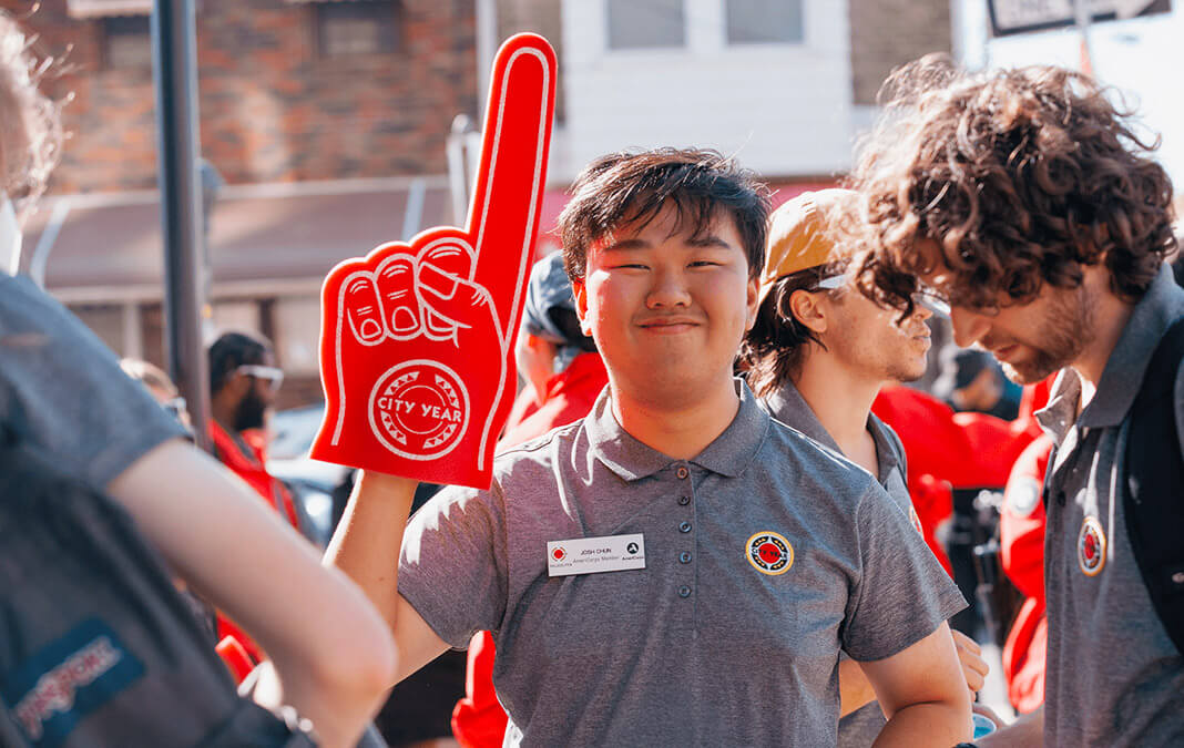 City Year volunteer wearing a red foam hand