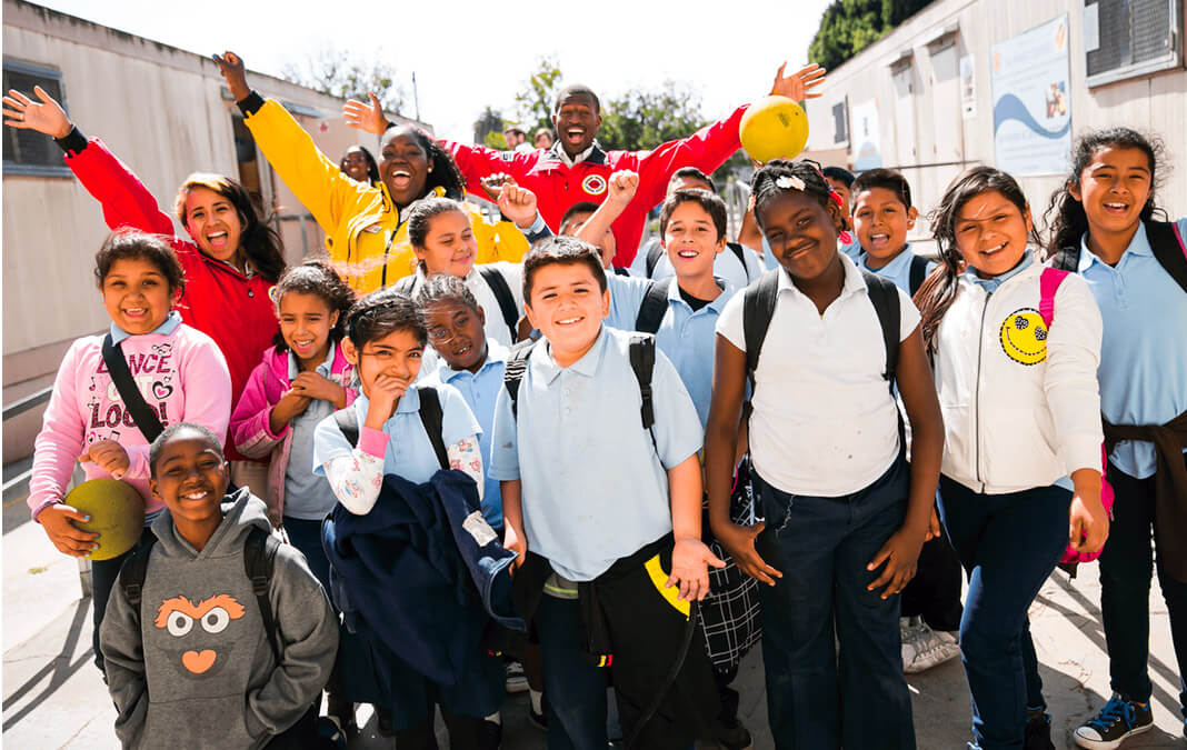 portrait of City Year volunteers with a group of students in Los Angeles smiling