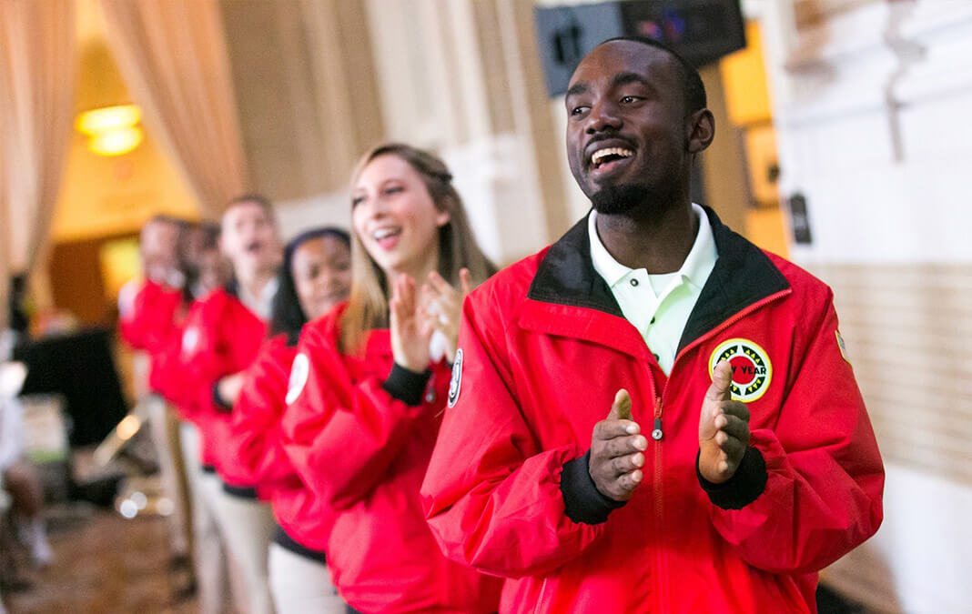 City Year volunteers in red jackets clapping and smiling