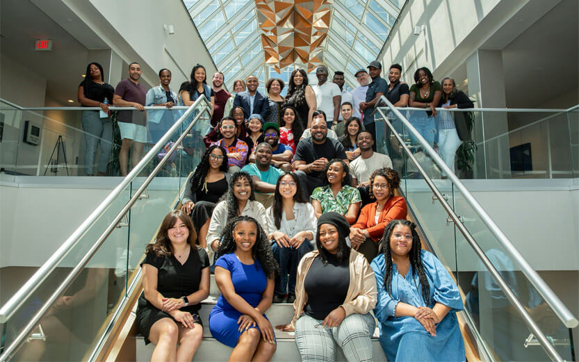 group shot of the Colors of Change team sitting on the stairs in an office building