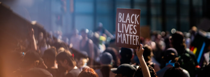 a group of protestors with a Black Lives Matter sign raised