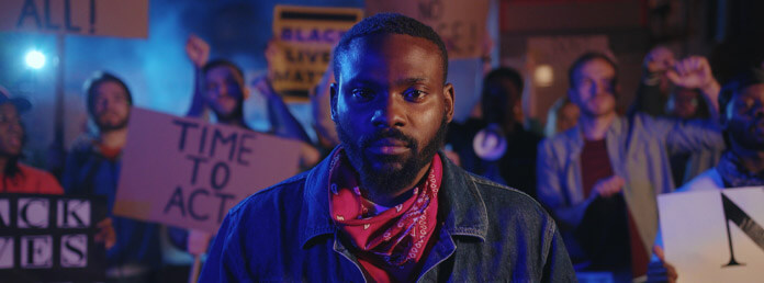 a black man standing in front of protestors