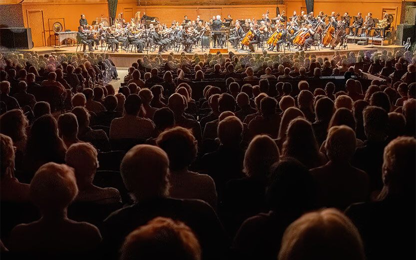 an audience sitting in front of a stage with an orchestra