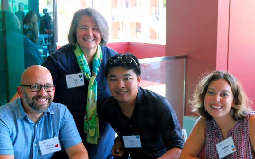 a group of four CSH workers wearing name badges and smiling