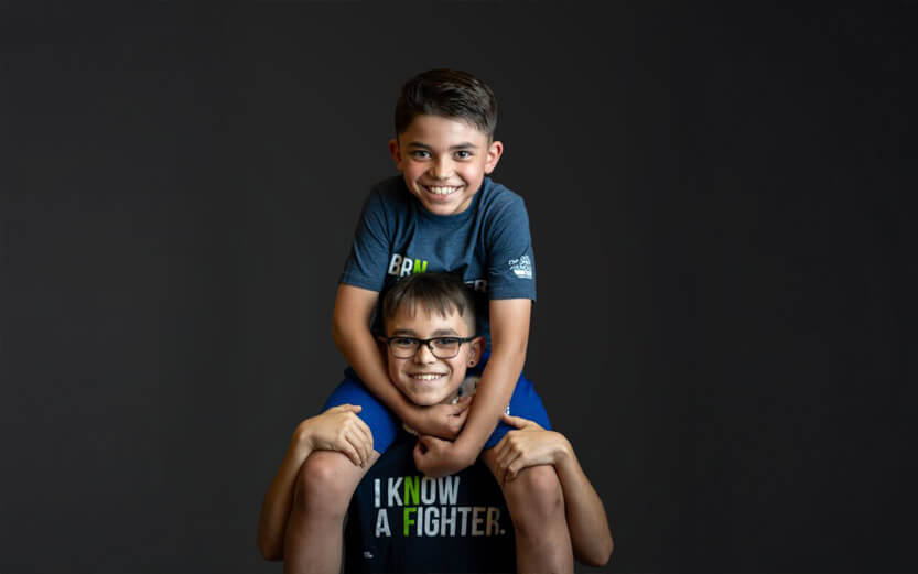 brothers, one sitting on the other's shoulders