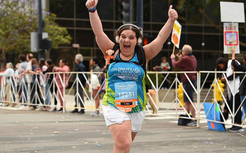 teen running a marathon giving the thumbs up sign and smiling big