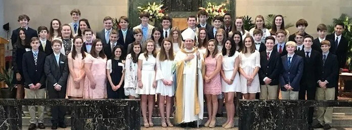 a group shot of a youth group with the diocese leader