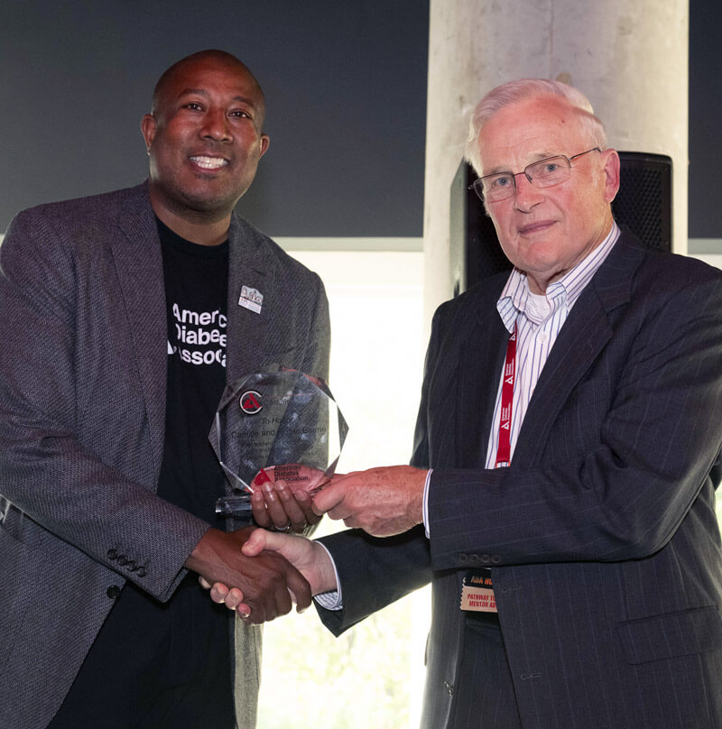 Chuck Henderson, CEO(left), presents a legacy award celebrating the generosity of Camille and Roger Blume.