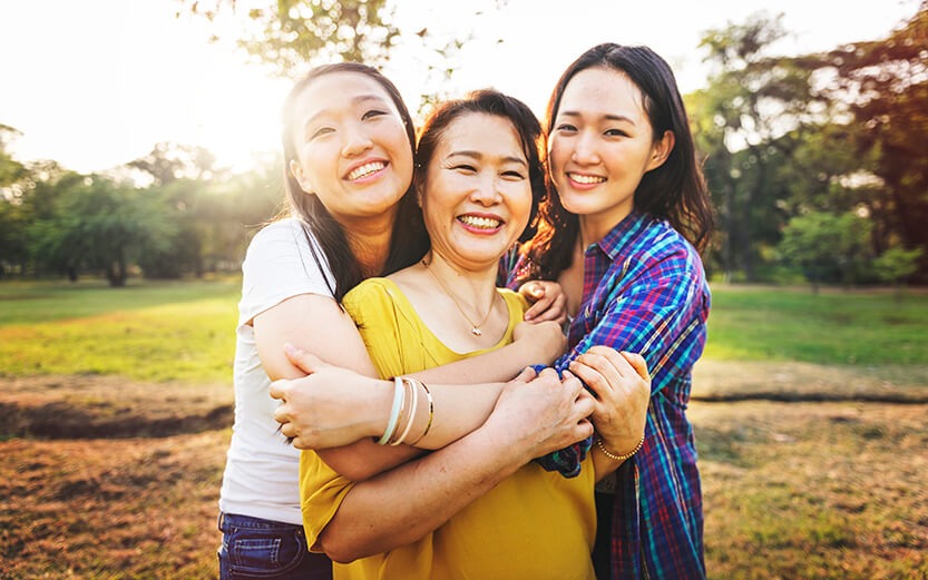 3 Asian women spanning 3 generations embracing