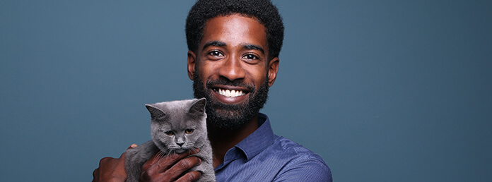 man with a cat in front of a background