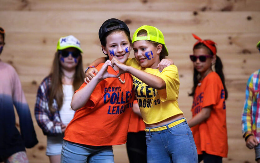 two girls making a heart with their hands