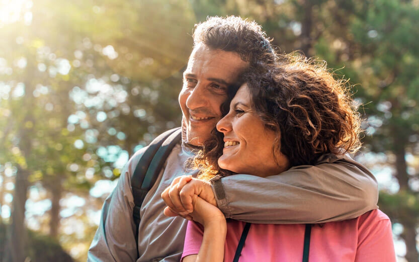 close up of couple smiling, man with his arm around the woman's shoulder