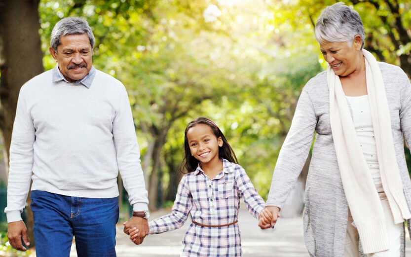 grandparents walking holding hands with granddaughter
