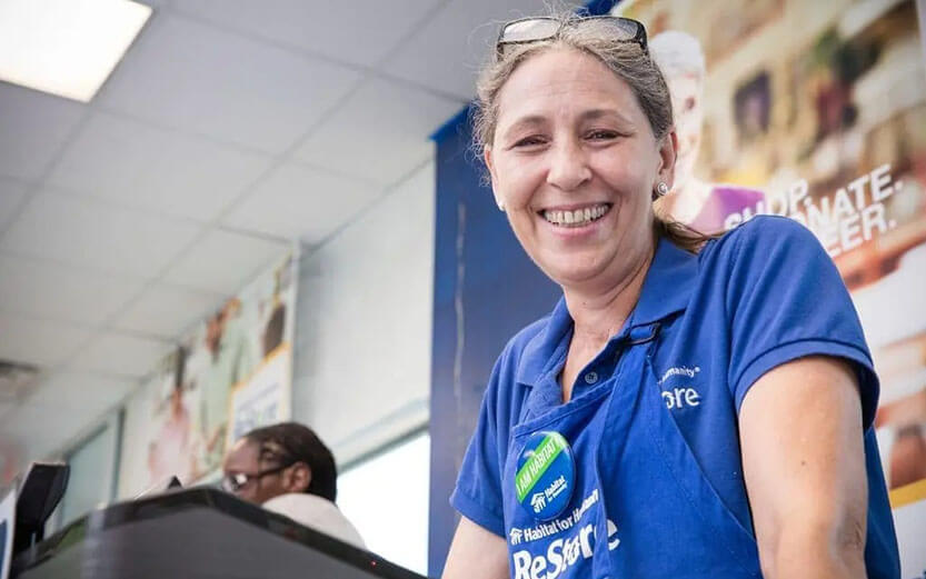 An adult working the cash register at Habitat for Humanity ReStore.