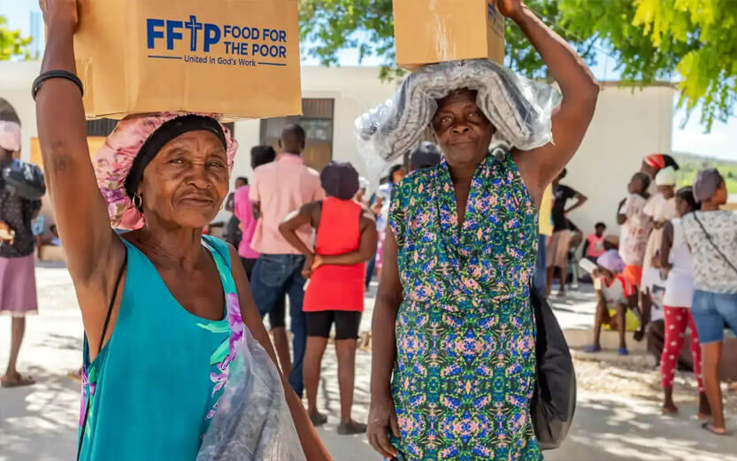 two senior women carrying FFTP supply boxes on their heads