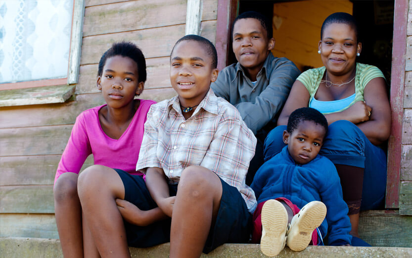 family of five sitting on the front steps of their home