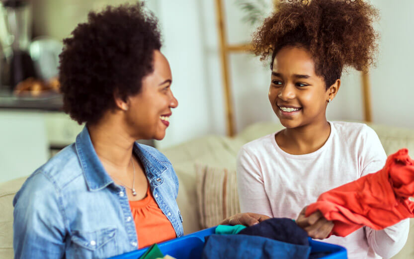 mother and daughter going through a bin of donated clothes