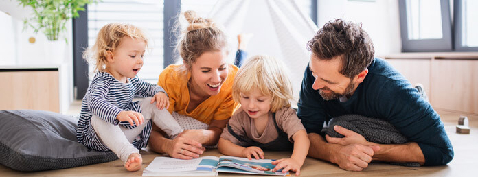 family of four reading a story on the floor