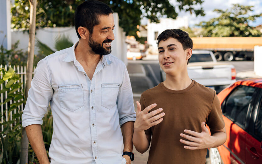 a father and teen son walking and talking